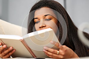 Smiling black woman read story book at home