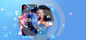 Smiling black woman showing smarthone with web3 futuristic hologram icons
