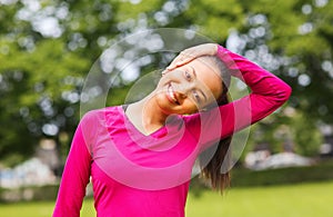 Smiling black woman stretching leg outdoors