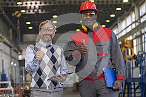 Smiling Black Worker in Protective Workwear And Caucasian Production Manager Giving Thumbs Up