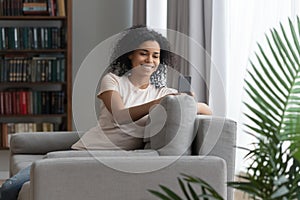 Smiling black young woman having video call on cellphone