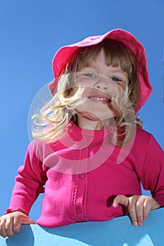 Smiling blond girl with pink clothes