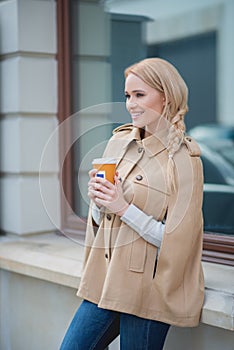 Smiling blond woman pausing for a mug of coffee photo