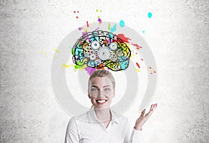Smiling blond woman showing brain with cogs