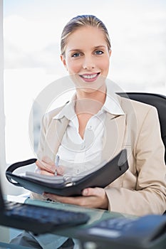 Smiling blonde businesswoman holding datebook