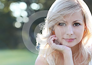 Smiling blonde girl. Portrait of happy beautiful young woman, outdoors. Bokeh