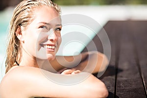 Smiling blonde leaning on pools edge