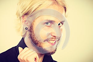 Smiling blonde man with piercing