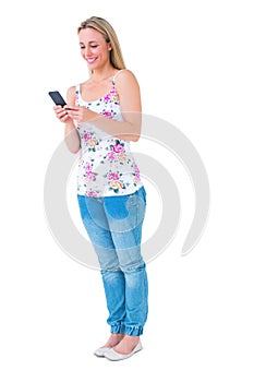 Smiling blonde sending a text message