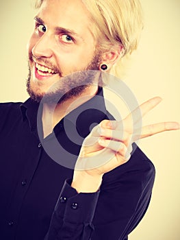 Smiling blonde showing peace gesture