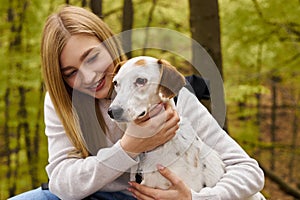 Smiling blonde woman hugging her dog