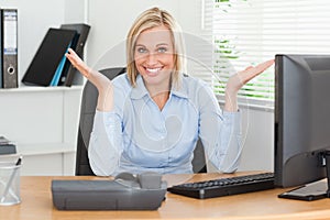 Smiling blonde woman sitting behind desk