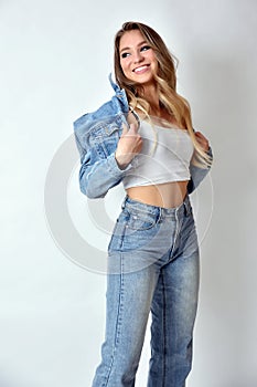 Smiling blonde woman wearing jeans jacket and trousers