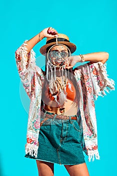 Smiling bohemian girl holding dreamcatcher in front of face