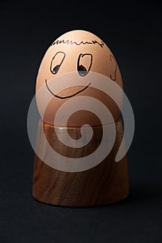 Smiling boiled egg on the wooden egg holder