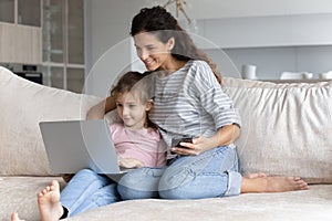 Smiling bonding family using different gadgets at home.