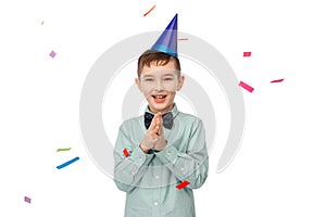 smiling boy in birthday party hat clapping hands