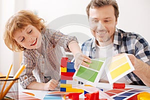 Smiling boy choosing necessary pattern with green color