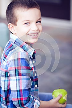 Smiling boy eating apple