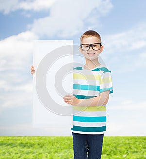 Smiling boy in eyeglasses with white blank board