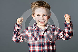 Smiling boy with freckles raising strong fists for tough health