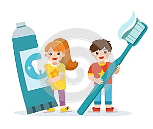 Smiling boy and girl standing, holding toothbrush and toothpaste.