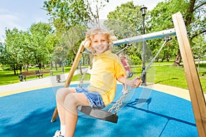 Smiling boy and girl swing in opposite directions