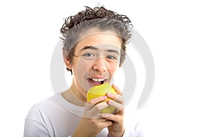 Smiling boy going to bite a yellow apple