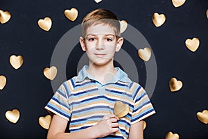 Smiling boy on golden hearts background