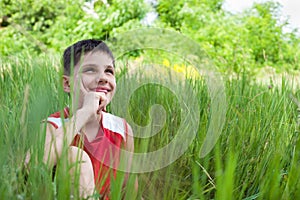 Smiling boy in the green grass