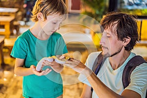 Smiling boy and his father holding python in hands