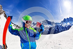 Smiling boy hold ski and take image with his phone