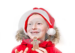 Smiling boy holding gingerbread man.