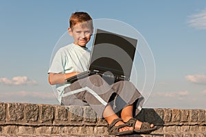 Smiling boy holding a laptop