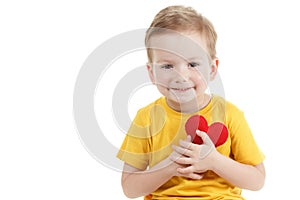 Smiling boy holding a red heart figurine. symbol of love, family, . Concept of the family and children.