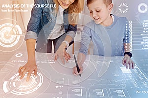 Smiling boy holding a stylus while drawing with his mother