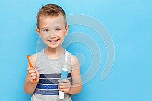 Smiling boy holds in his hands electric and manual toothbrushes photo