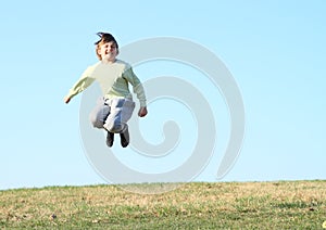 Smiling boy jumping on meadow