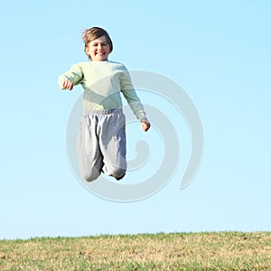Smiling boy jumping on meadow
