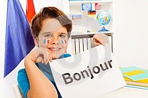 Smiling boy learning French at the classroom