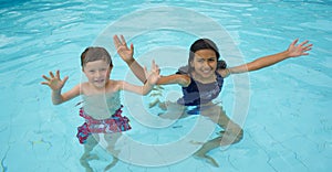 Smiling boy and little girl swimming