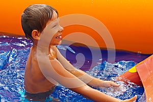 Smiling boy near waterslide.