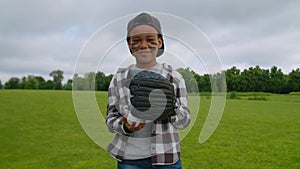 Smiling boy pitcher throwing baseball ball into baseball glove