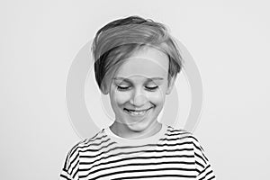 Smiling boy posing at studio. Children style and fashion. Laughing child. Kid looking down