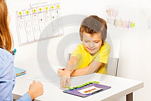 Smiling boy puts coins during developing game