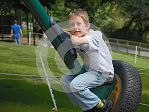 Smiling boy resting on large spin-swing