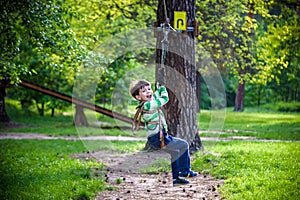 Smiling boy rides a zip line. happy child on the zip line. The kid passes the rope obstacle course