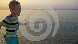 Smiling Boy Running along the Sea