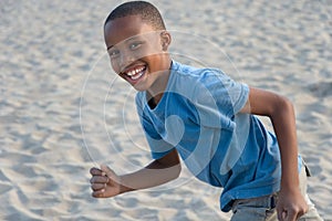 smiling boy running with sand