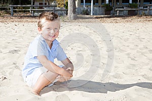 Smiling boy sit on sand beach during vaction day
